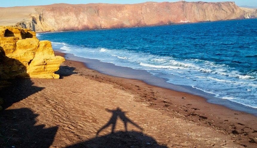 Dramatic ocean cliffs and red sands of Paracas National Reserve along the Pacific coast of Ica, Peru