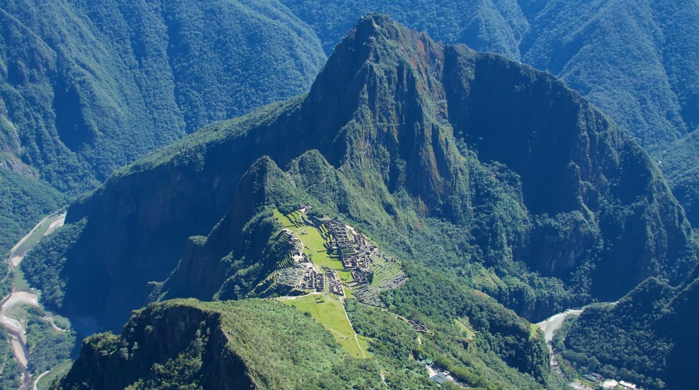 Vista panorámica colosal a 3,082 msnm desde la cumbre de Montaña Machu Picchu con Huayna Picchu de fondo y el cañón del Urubamba